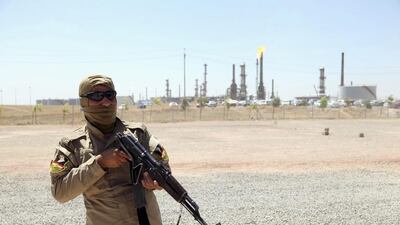 A member of Kurdish security forces takes up position with his weapon as he guards an oil refinery on the outskirts of Mosul, June 22, 2014. U.S. Secretary of State John Kerry met Iraq's Prime Minister Nuri al-Maliki in Baghdad on Monday to push for a more inclusive government, even as Baghdad's forces abandoned the border with Jordan, leaving the entire Western frontier outside government control. Picture taken June 22, 2014. REUTERS/Azad Lashkari (IRAQ - Tags: CIVIL UNREST POLITICS MILITARY CONFLICT ENERGY TPX IMAGES OF THE DAY)