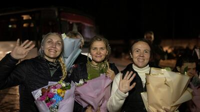 Former Ukrainian prisoners of war wave as they arrive in Zaporizhzhia, Ukraine, after being freed. Reuters