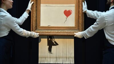 The newly completed work by artist Banksy entitled 'Love is in the Bin' was created when the painting 'Girl with Balloon' was passed through a shredder at Sotheby's auction house in London last year (Photo by Ben STANSALL / AFP)