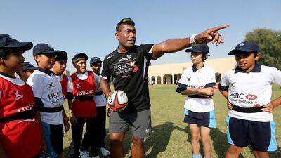 Students from the Rashid School for Boys in Nad Al Sheba get some instruction from former Fiji rugby sevens captain Waisale Serevi during a clinic at Dubai . Satish Kumar / The National