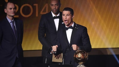 Cristiano Ronaldo reacts to winning the Ballon d'Or on Monday night with Thierry Henry, back right, and Amaury Sport Organisation president Jean-Etienne Amaury, back left, looking on. Olivier Morin / AFP