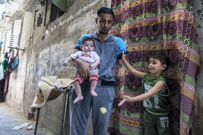 Islam Amoon, seen with his son Dia, 4, and 3-month-old baby Mohammed outside their home in Buriej, plays in goal. Heidi Levine for The National