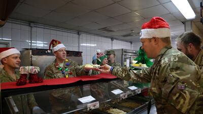 Members of the U.S. military are served dinner on Christmas Day at the Resolute Support Headquarters in Kabul, Afghanistan. (AP Photo/Rahmat Gul)