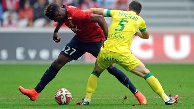 Lille forward Divock Origi, left, dribbles by Nantes defender Olivier Veigneau during Lille's victory in Ligue 1 on Sunday. Francois Lo Presti / AFP / September 14, 2014