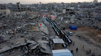 Palestinians gather for a mass fast-breaking iftar meal organised by the Turkish IHH Foundation, amid the rubble of destroyed buildings in Gaza city. AFP