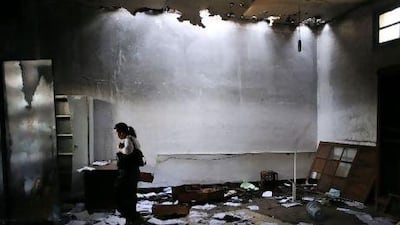 A local woman looks at the burnt remains of a room within a building complex that used to serve as the police station of Menzel Bourguiba. Lindsay Mackenzie for The National
