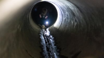 An anti-government protester attempts to escape Hong Kong Polytechnic University by going through a sewer in Hong Kong. Getty Images