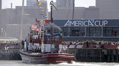 A fireboat passes by spectators at Pier 27 who were watching Emirates Team New Zealand and Oracle Team USA at the America's Cup on Tuesday. Eric Risberg / AP Photo