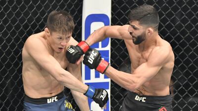 Amir Albazi (L) of Iraq punches Zhalgas Zhumagulov of Kazakhstan in a flyweight fight during the UFC 257 event inside Etihad Arena on UFC Fight Island. Jeff Bottari/Zuffa LLC