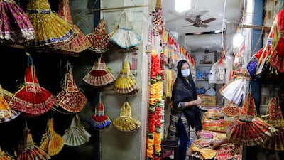 A Hindu woman wearing a mask shops for religious items on the eve of the Hindu festival Navratri in Prayagraj, India. AP Photo
