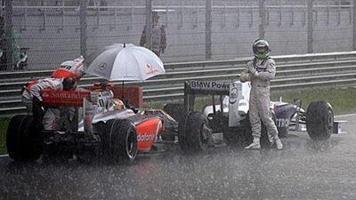 BMW Sauber's Nick Heidfeld, right, and McLaren's Lewis Hamilton wait on the track during a rain delay during last year's Malaysian F1 Grand Prix. The race was not restarted.
