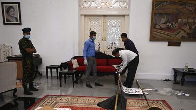 Police officials gather evidence at the president’s official residence after it was overrun by anti-government protesters on July 9. AFP
