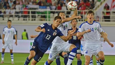 Japan's Yoshinori Muto, left, fights for the ball with Batyrov and Ilya Tamurkin. AFP