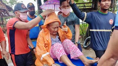 A woman is rescued from her home. Photo: EPA