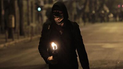 A hooded demonstrator prepares to hurl a Molotov cocktail at riot police during clashes that broke after a rally marking the anniversary of the killing of teenager Alexis Grigoropoulos by a Greek police officer, in Athens, Greece. Orestis Panagiotou / EPA