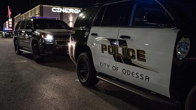 Police cars and tape block off a crime scene where a gunman was shot and killed at Cinergy Odessa movie theater in Midland, Texas. Officials say the unidentified suspect killed 5 people and injured 21 in Midland and nearby Odessa. AFP
