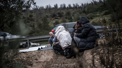 Motorists take shelter from an incoming Iranian missile attack in a ditch on the side of the motorway in Latrun, Israel. AFP
