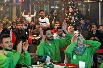 Palestinian supporters cheer their team on during the 2019 AFC Asian Cup Group B football match taking place in Sharjah between Syria and Palestine in the West Bank city of Ramallah on January 6, 2019. / AFP / ABBAS MOMANI