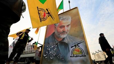 Members of Iraq's Kataib Hezbollah militia hold a picture of Iranian general Qassem Suleimani before his funeral procession in Baghdad on January 4, 2020. Reuters