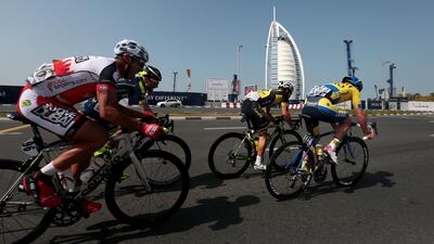 The lead pack of cyclists ride past Burj Al Arab during the fourth stage of the Dubai Tour cycling race.
