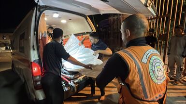 The body of one of the people killed in the latest strike is taken away in an ambulance. AFP