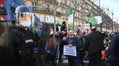 Demonstrators hold placards and wave Algerian national flags during a rally in Paris in support of an opposition movement in Algeria. AFP