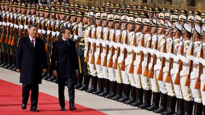 Mr Xi and Mr Macron review an honour guard at the official welcoming ceremony in Beijing. AFP