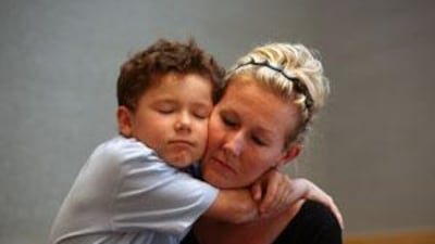 Marnie Pearce, 40, holds her son Laith, 7, before turning herself into Dubai Courts.