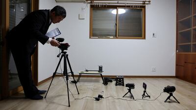 A real estate consultant conducts a 'ghost investigation' at a house where the previous owner had died last year, in Chiba Prefecture, near Tokyo, Japan. Reuters