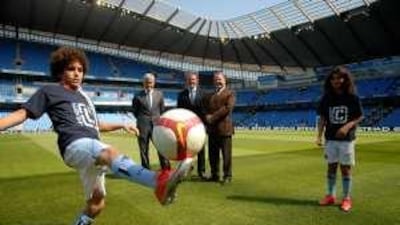 From left, Etihad mascot Saif Al Sheikh Khazaal, Mark Hughes, the Manchester City manager, Garry Cook, the football club's chief executive, James Hogan, the Etihad chief executive, and Khalid Al Nahyan, a City mascot, at the City of Manchester Stadium yesterday.