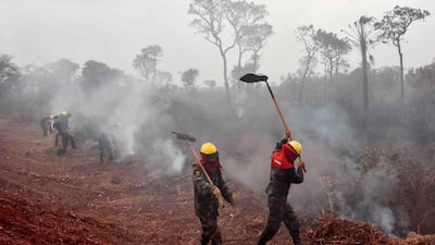 Bolivian soldiers combat forest fires in Otuquis National Park, in the Pantanal ecoregion of southeastern Bolivia, on August 26, 2019. Like his far right rival President Jair Bolsonaro in neigboring Brazil, Bolivia's leftist leader Evo Morales is facing mounting fury from environmental groups over voracious wildfires in his own country. While the Amazon blazes have attracted worldwide attention, the blazes in Bolivia have raged largely unchecked over the past month, devastating more than 9,500 square kilometers (3,600 square miles) of forest and grassland. / AFP / Aizar RALDES