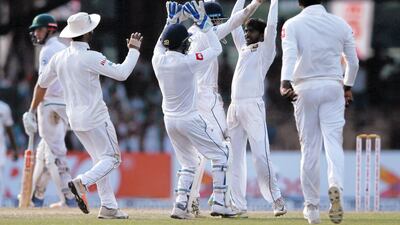 Sri Lanka's Akila Dananjaya, centre, celebrates with his teammates after taking the wicket of South Africa's Keshav Maharaj. Dinuka Liyanawatte / Reuters