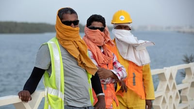 Mangrove area roadwork workers cover themselves from the elements because of a sandstorm, Abu Dhabi. Victor Besa / The National