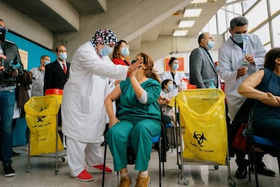 Nurse Meherzia Hammami celebrates receiving a Covid-19 vaccine with friend and fellow nurse Emna Abdelnour, who administered the Sputnik V shot in Tunis. Erin Clare Brown / The National