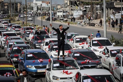 A groom stands on a car as he arrives at a mass wedding ceremony for 300 couples in the Gaza Strip. AFP