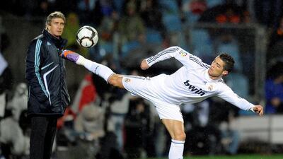 Real Madrid's Portuguese forward Cristiano Ronaldo (R) controls a ball next to Real Madrid's Chilean coach Manuel Pellegrini during a Spanish league football match against Getafe at Alfonso Perez stadium on March 25, 2010, in Getafe near Madrid. AFP PHOTO/JAVIER SORIANO.
