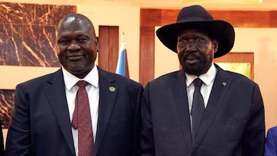 South Sudanese President Salva Kiir stands with First Vice President Riek Machar as they attend a swearing-in ceremony at the State House in Juba, on February 22, 2020. AFP