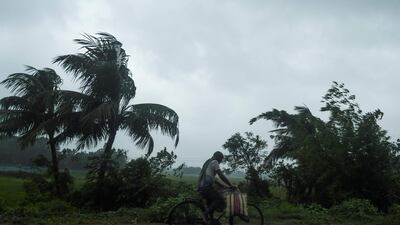 A man rides a bicycle under the rain ahead of the expected landfall of cyclone Amphan in Midnapore, West Bengal. AFP