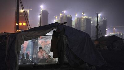 A worker uses a laptop inside his dormitory near a residential construction site in Hefei, Anhui province. A raft of China data over the coming week will give the first indications of the economy’s third-quarter performance, after conflicting signals suggested that more stimulus measures may be needed to ensure a sustained recovery. Reuters