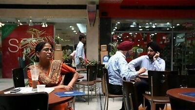 Indian people take a break with a cup of coffee at an upmarket shopping mall in the satellite town of Gurgaon. Anna Zieminski / AFP