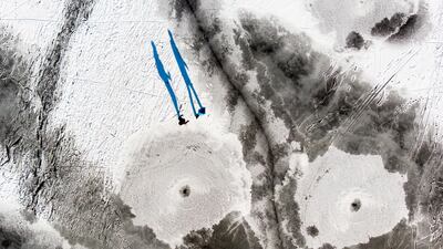 A picture taken with a drone shows people walking on the frozen 'Lac des Tailleres' lake, located 1040 meters above sea level, on the Jura mountain massif in La Brevine, Switzerland. EPA