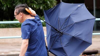 A man struggles with an umbrella while walking against strong wind as Typhoon Nida hits Hong Kong. Tyrone Siu / Reuters