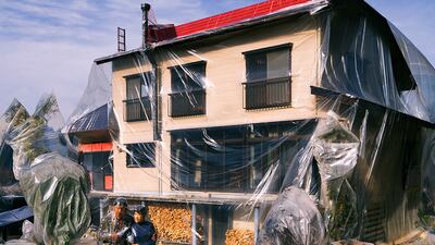 A couple shrink wrapped outside their home.