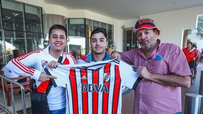 Brian Arnez, 27, Emiliano Olivetti, 21 and Ricardo Olivetti, 59 hold a River Plate shirt proudly.