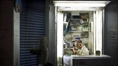 Niaz Ahmed, a watch repairman, works in his tiny store on the ground floor of an apartment tower on Hamdan Street. Ahmed arrived from Karachi, Pakistan, by ship about 40 years ago to work as a watch repairer in the old souq and is one of the few remaining vendors from the original market, which was destroyed in a fire in 2003. Antonie Robertson / The National