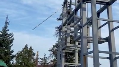 A Ukrainian fighter throws a Donetsk Republic flag from a monument in Lyman. Reuters