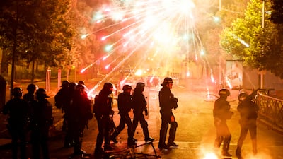 French police stand in position as fireworks go off during clashes in Nanterre, Paris. Reuters