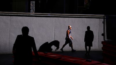 A man is lit by the sun as he walks with other pedestrians along a street on a spring day in the central business district (CBD) of Sydney, Australia, October 9, 2017. REUTERS/David Gray