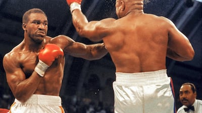 Evander Holyfield (left) connects with a left hook to the chin of George Foreman as they compete for the WBC, WBA, IBF Heavyweight Titles, in a bout schedule for twelve rounds at the Trump Plaza Convention Center on April 19, 1991 in Atlantic City, New Jersey. Getty