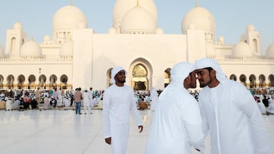 Emirati men greet each other after Eid prayers at Sheikh Zayed Grand Mosque in Abu Dhabi. Christopher Pike / The National